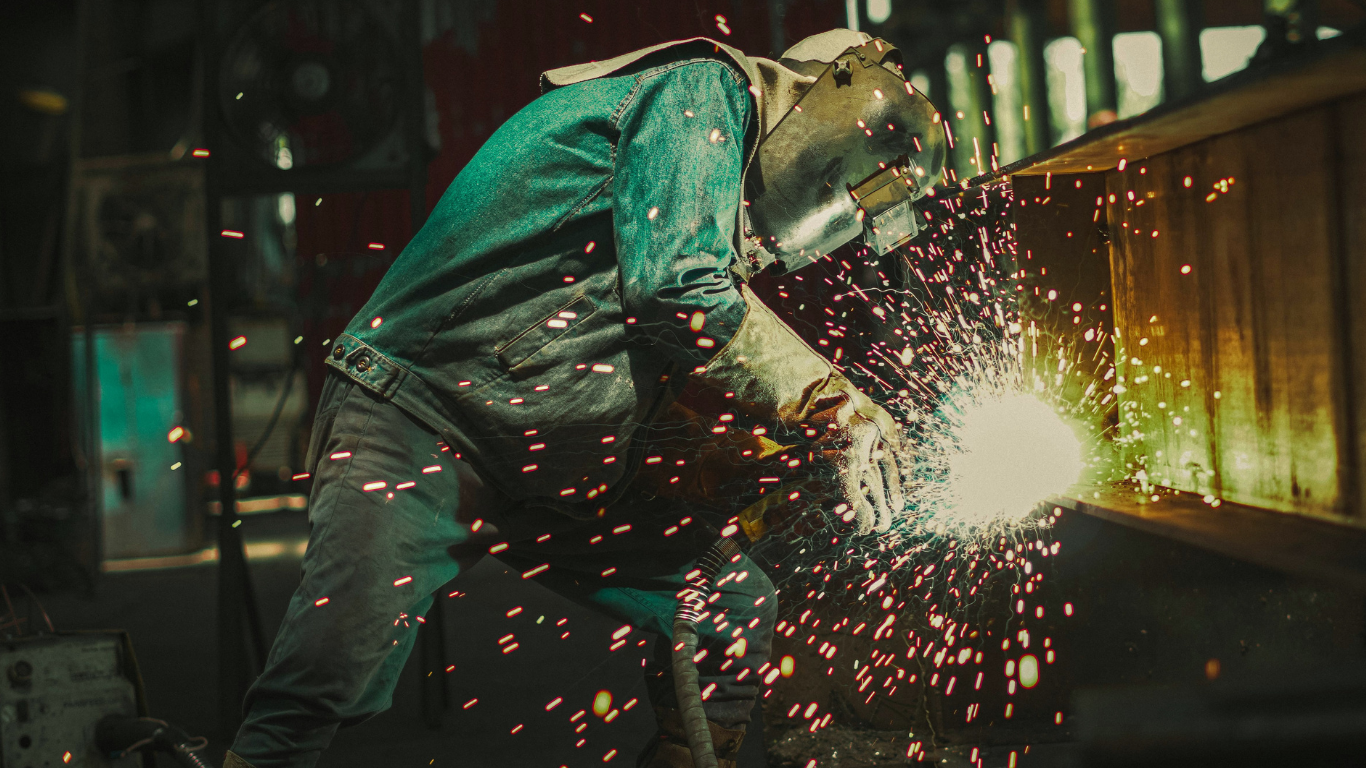 Welder using protective equipment during industrial fabrication